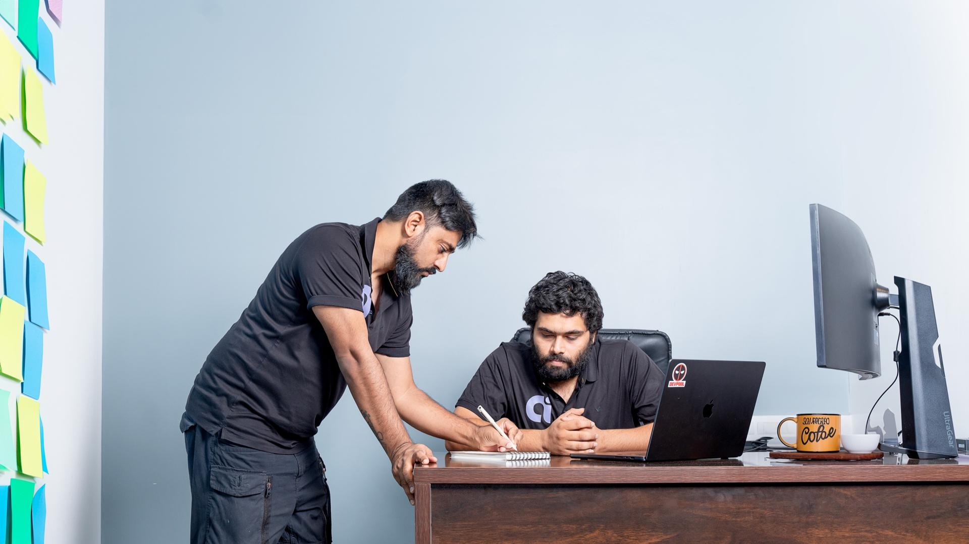 The founders working through a build at the whiteboard wall