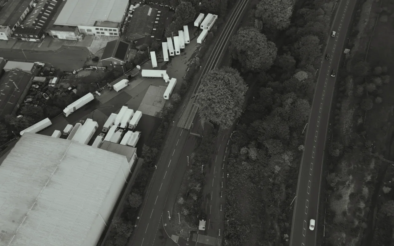 A truck depot beside a warehouse, seen from the air.